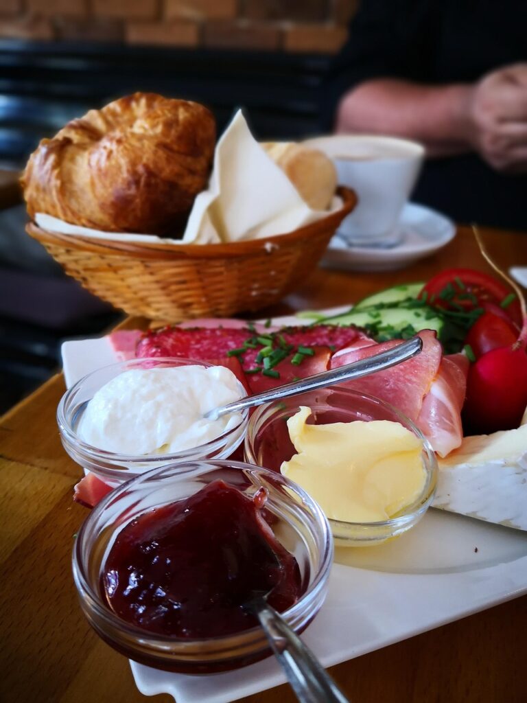 Croissants, butter, jelly and prosciutto breakfast.