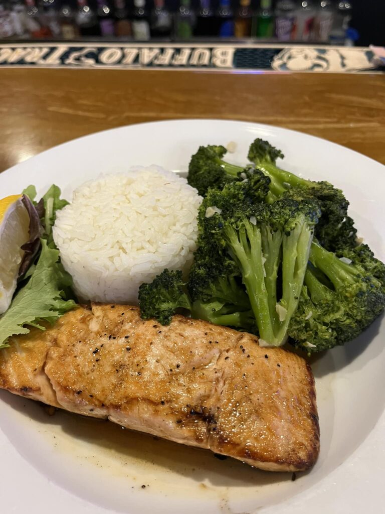 Salmon, broccoli and rice on a white plate.