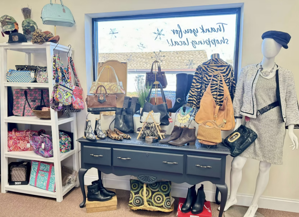 Interior of the Revival Boutique showing various handbags, boots, necklaces and a mannequin in a dress with a cap on.