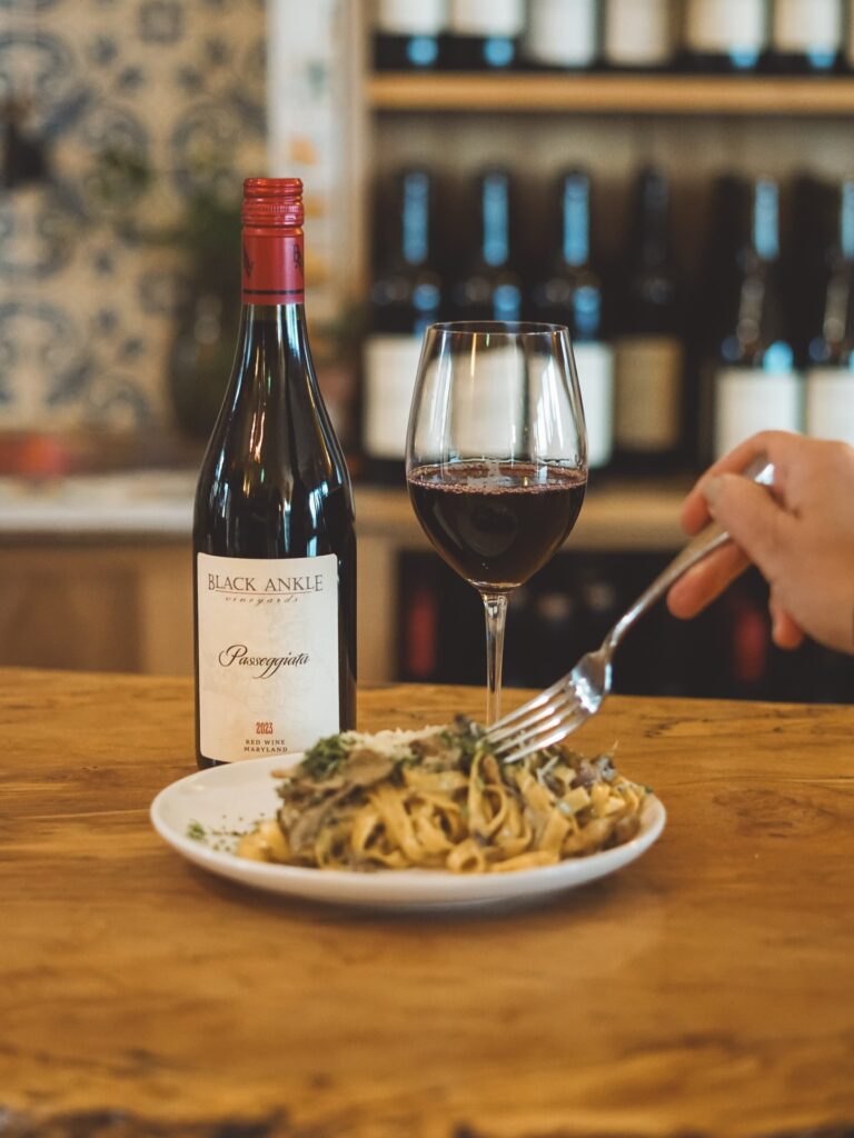 spaghetti, wine and some wine bottles on shelves.
